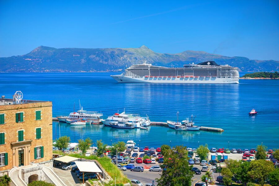 A cruise ship alongside the quay above a harbour town